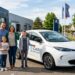 Famille française devant une voiture électrique neuve dans un concessionnaire