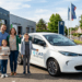 Famille française devant une voiture électrique neuve dans un concessionnaire