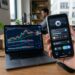 Smartphone affichant une application de paiement crypto pres d un ordinateur
