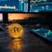 Pièce de bitcoin dorée devant un graphique boursier en hausse