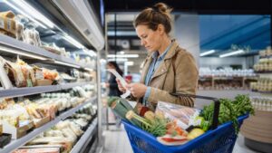 Cliente comparant un ticket de caisse et des courses au supermarché