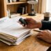 Mains tenant des clés de voiture près de documents bancaires refusés