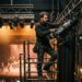 technicien du spectacle ajustant du matériel d'éclairage en coulisses de théâtre