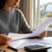 Personne consultant des documents de contrat d'assurance emprunteur à son bureau
