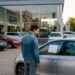 Personne regardant le prix affiché sur une voiture de leasing en concession
