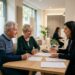 Couple senior signant un dossier de crédit immobilier avec un conseiller
